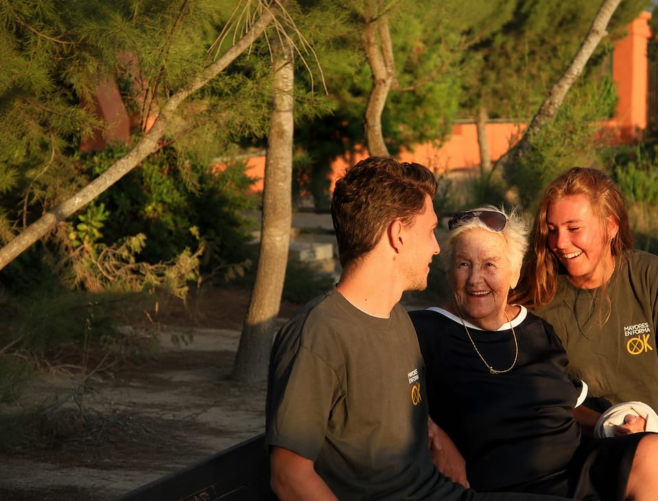 Equipo de Mayores en Forma OK con una persona mayor sonriendo al atardecer