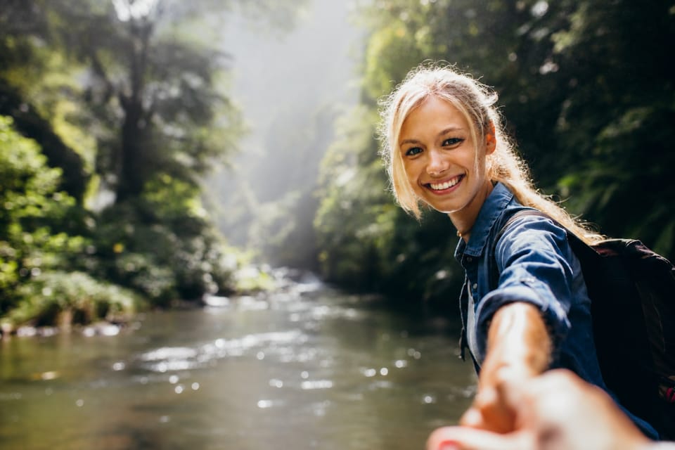 Persona mayor activa disfrutando de la naturaleza con ayuda de un profesional
